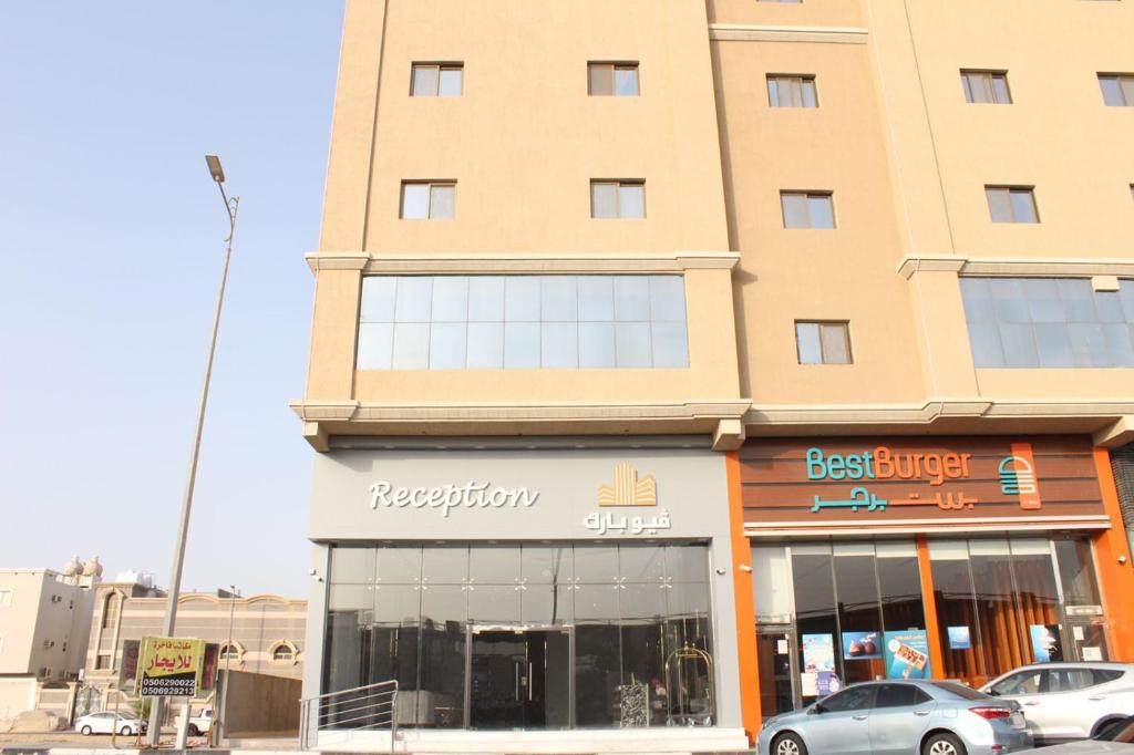 una tienda frente a un edificio con coches aparcados fuera en فيوبارك للشقق الفندقية, en Al Hofuf