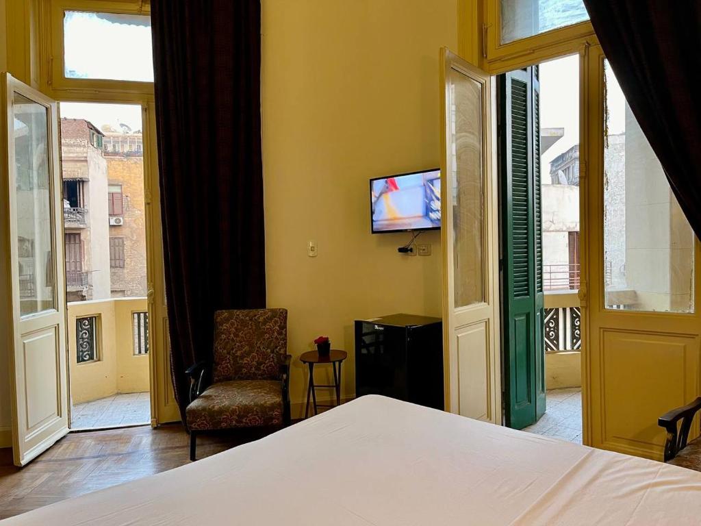 a bedroom with a bed and a tv and a window at Philo Hotel in Cairo