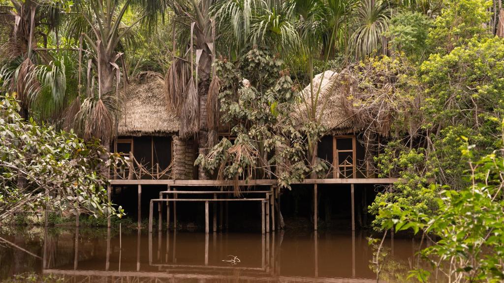 una casa en medio de un cuerpo de agua en Aparthotel Ayahuaska for SOLO travelers, en Iquitos