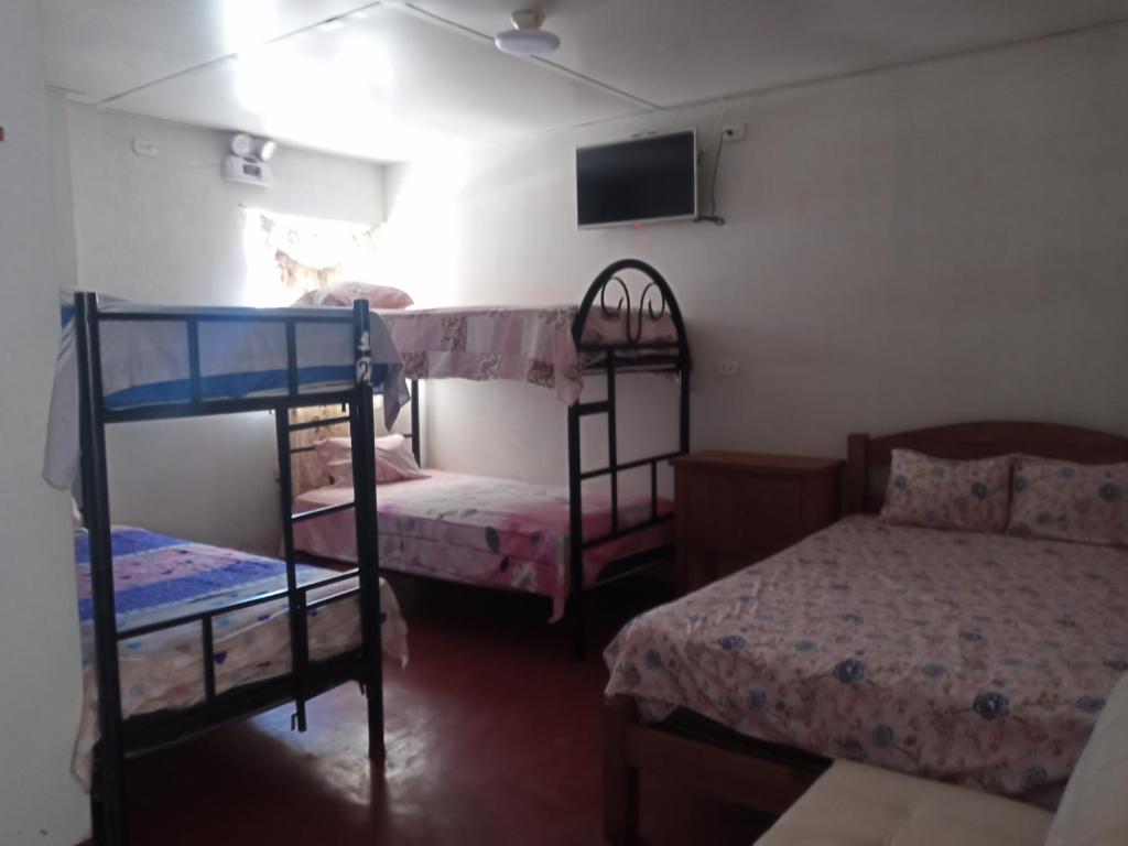 a bedroom with two bunk beds and a flat screen tv at MARANATHA in El Ñuro
