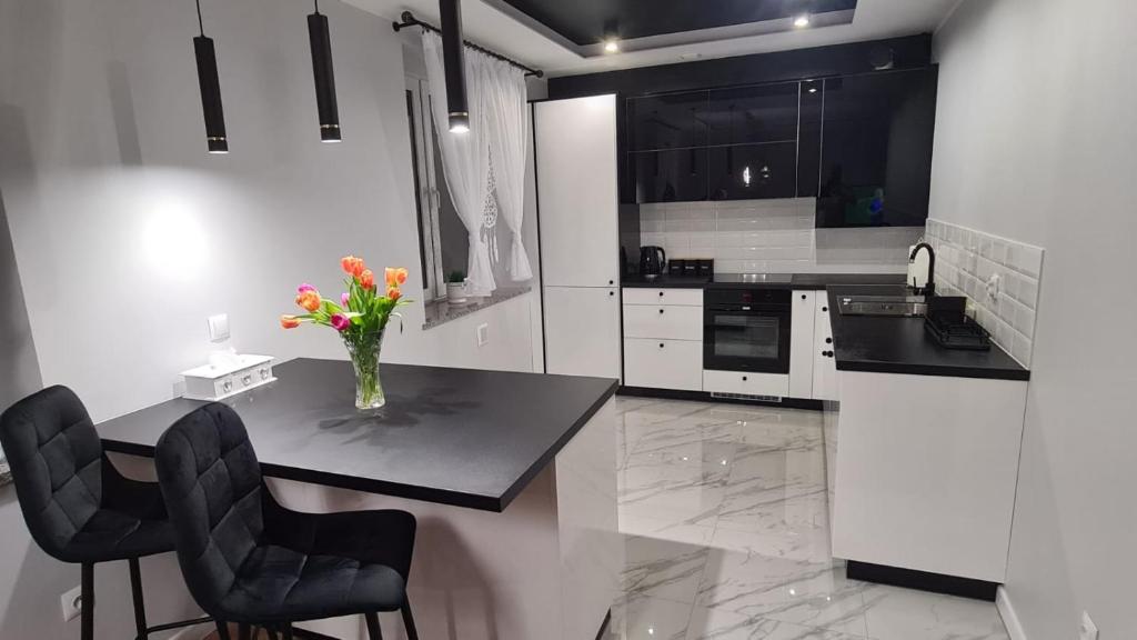 a kitchen with a table with a vase of flowers on it at Apartament Sofia Kowary in Kowary