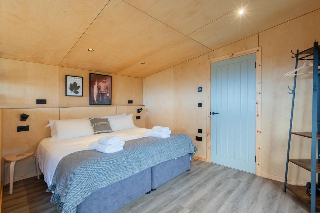 a bedroom with a bed with towels on it at Rustic Cabins, sea views from rewilded farm in St Andrews