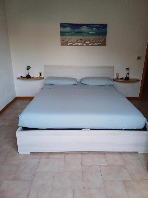 ein großes weißes Bett in einem Schlafzimmer mit zwei Regalen in der Unterkunft Home Mariarita in Montesilvano