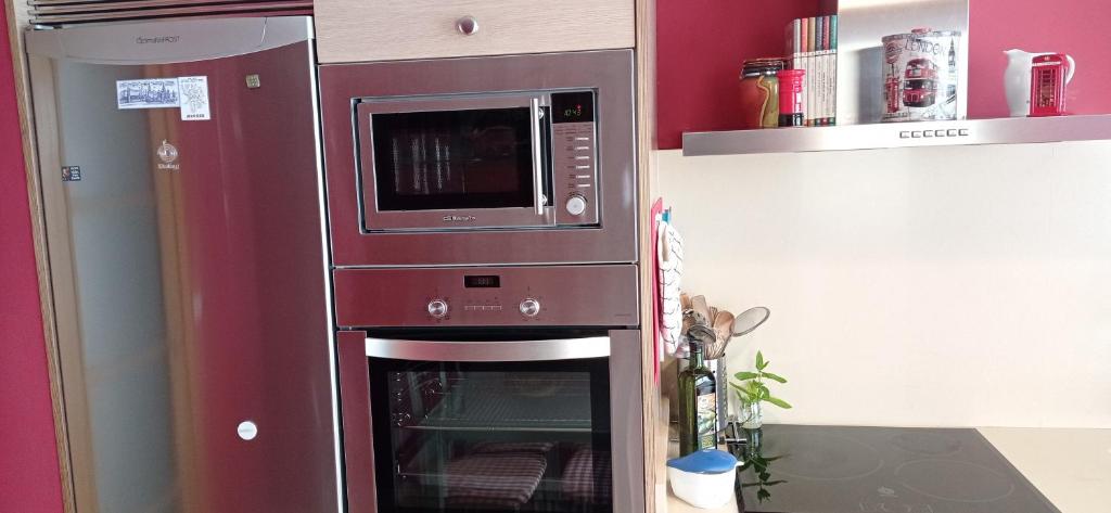 a microwave above an oven in a kitchen at Twin Room in shared Apartment in Cee