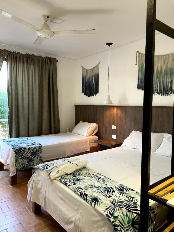 Postel nebo postele na pokoji v ubytování Hotel Macaw Cúcuta