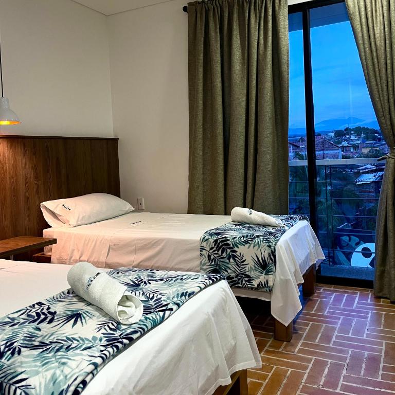 Postel nebo postele na pokoji v ubytování Hotel Macaw Cúcuta