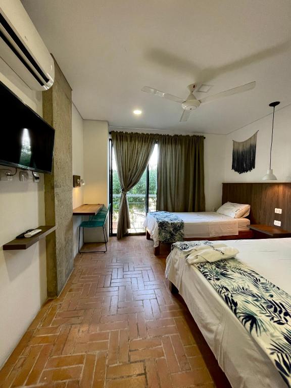 Postel nebo postele na pokoji v ubytování Hotel Macaw Cúcuta