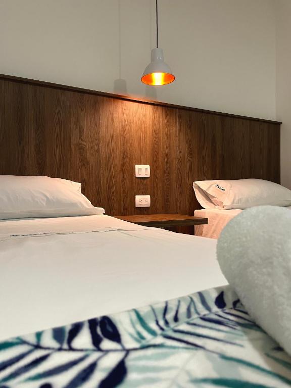 Postel nebo postele na pokoji v ubytování Hotel Macaw Cúcuta