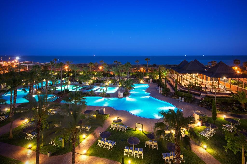 a view of a pool at a resort at night at Puerto Antilla Grand Hotel in Islantilla