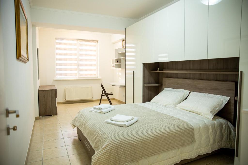 a bedroom with a large bed with two towels on it at Center Cozy Home in Chişinău