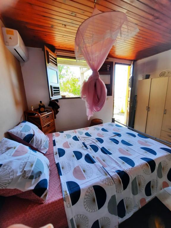 a bedroom with a bed with a comforter on it at Agréable F2 à Petite-Anse aux Anses d'Arlet MARTINIQUE in Quartier du Fond Fleuri