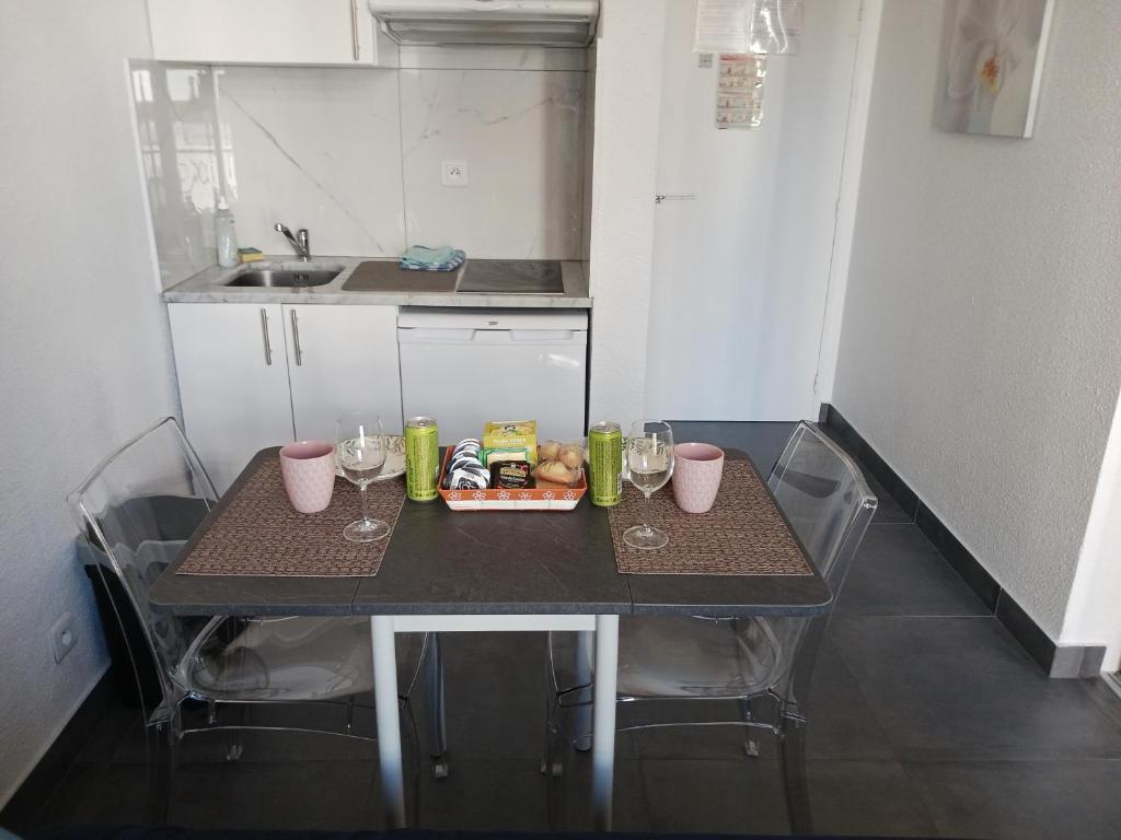 a small kitchen with a table with glasses and food on it at studio à 2 mn à pied de la plage in Nice