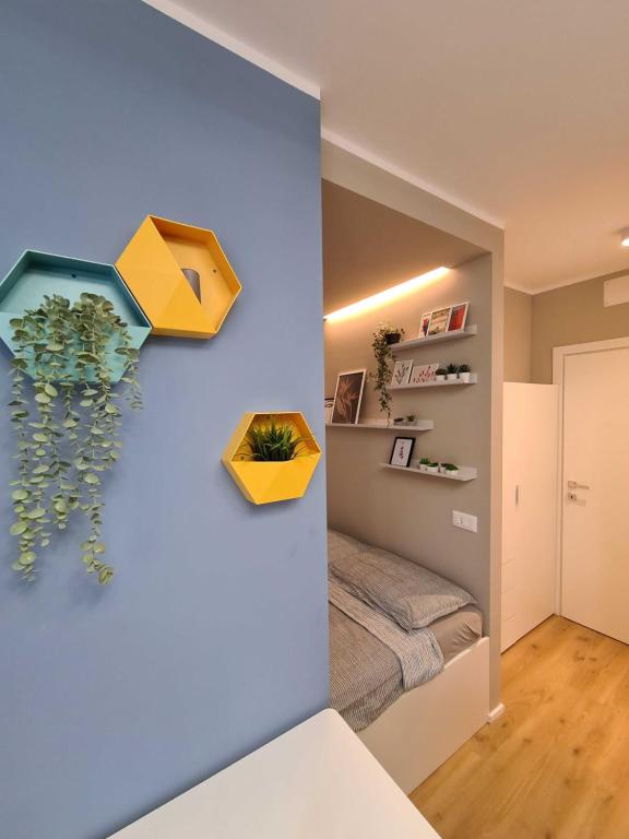 Habitación con cama y pared amarilla y azul. en Monolocale Mati - Holiday Home en Trento
