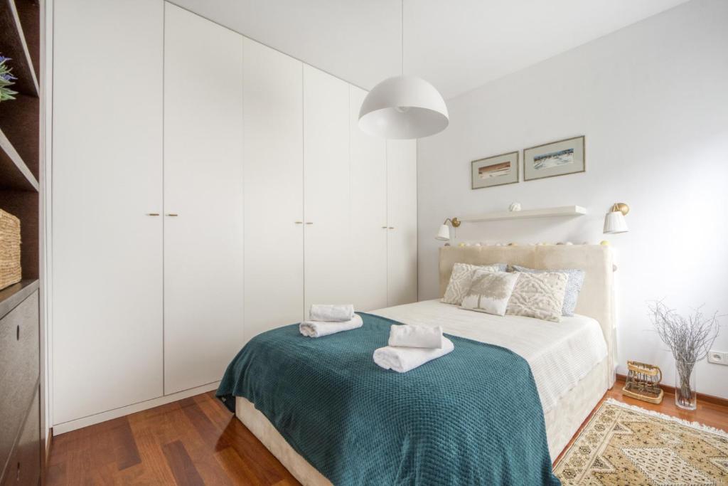 a white bedroom with a bed with towels on it at M&R Apartament Airport&Business Premium Marina Mokotów - parking - WiFi - Netflix - self check-in, terrace - guarded estate - WAW Chopin Airport in Warsaw