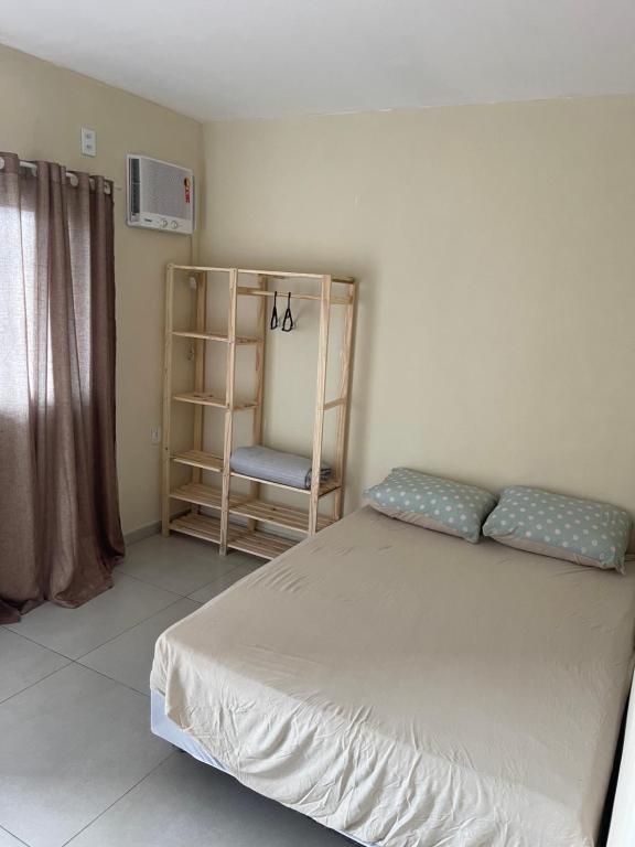 1 dormitorio con 1 cama y 1 silla en Apartamento Formosa 155, en Cabo Frío