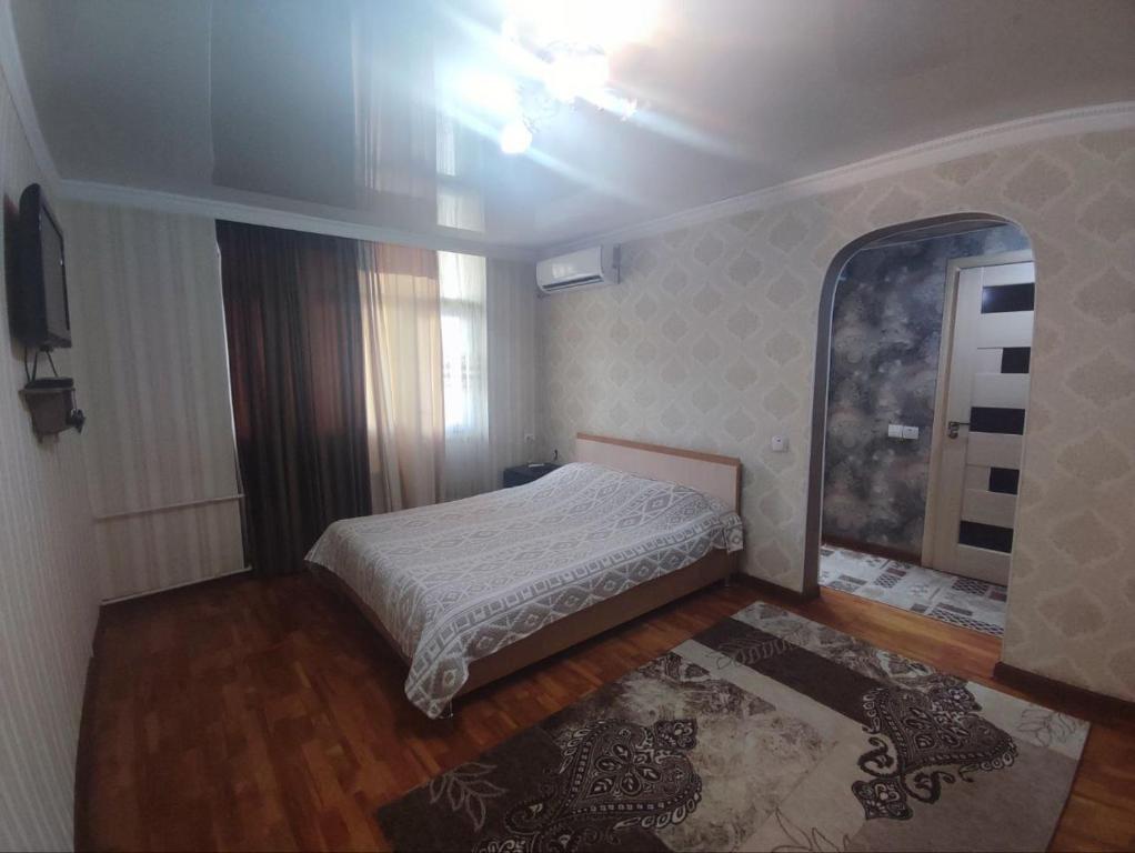 Dormitorio pequeño con cama y espejo en Комфортная квартира для 2х персон, en Bishkek