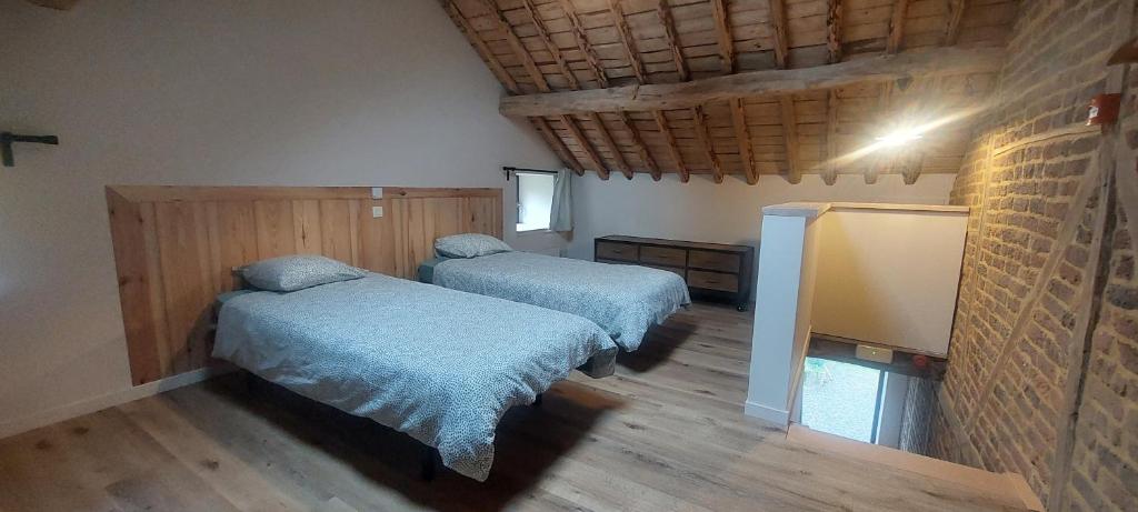um quarto com duas camas num quarto em La grange du Moulin em Érezée