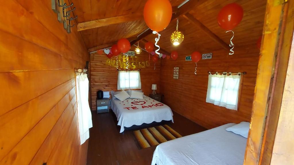 ラキラにあるCabaña campestre #1のキャビン内のベッドと風船が備わる客室です。