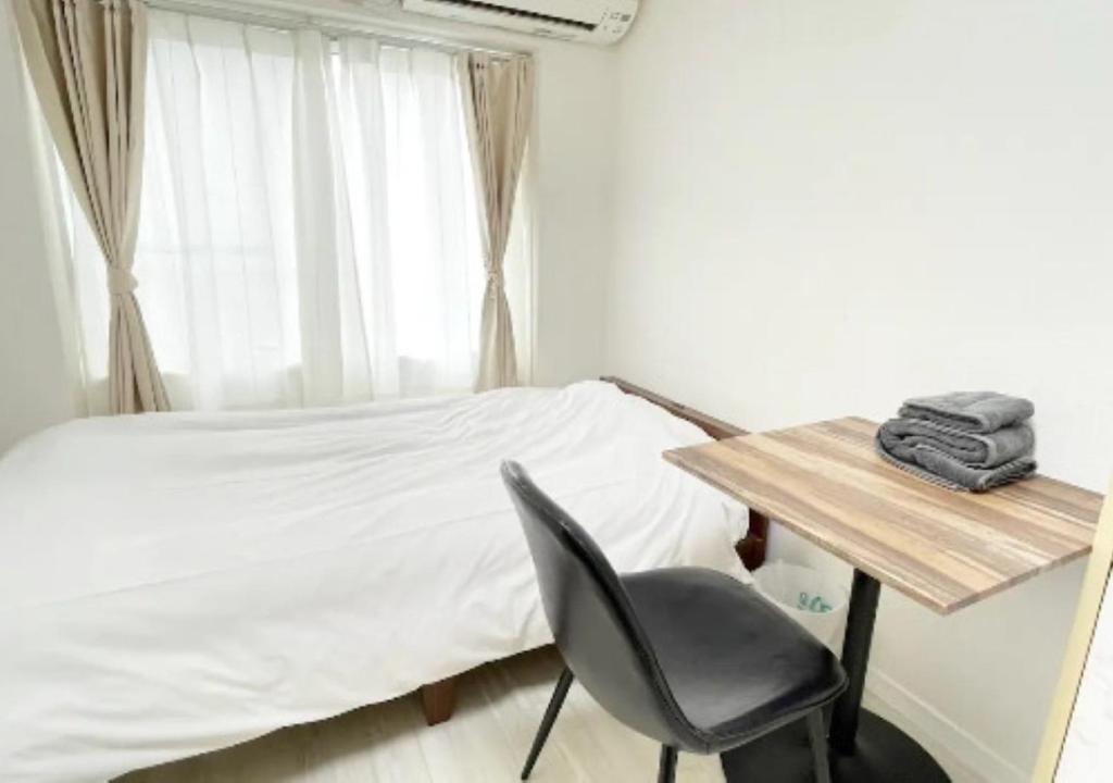 een slaapkamer met een bed, een bureau en een stoel bij Beverly Homes Osaki Room 203, Room 205, Room 301, - Vacation STAY 89062v in Tokyo