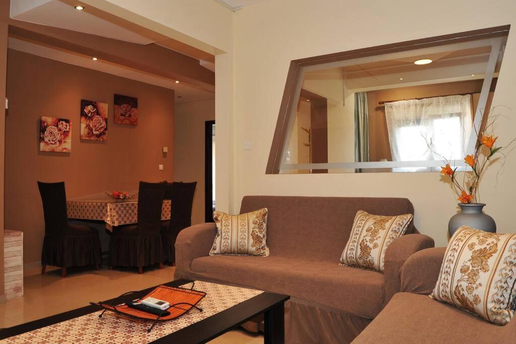 a living room with a couch and a mirror at Elpidas Apartment in Kalabaka
