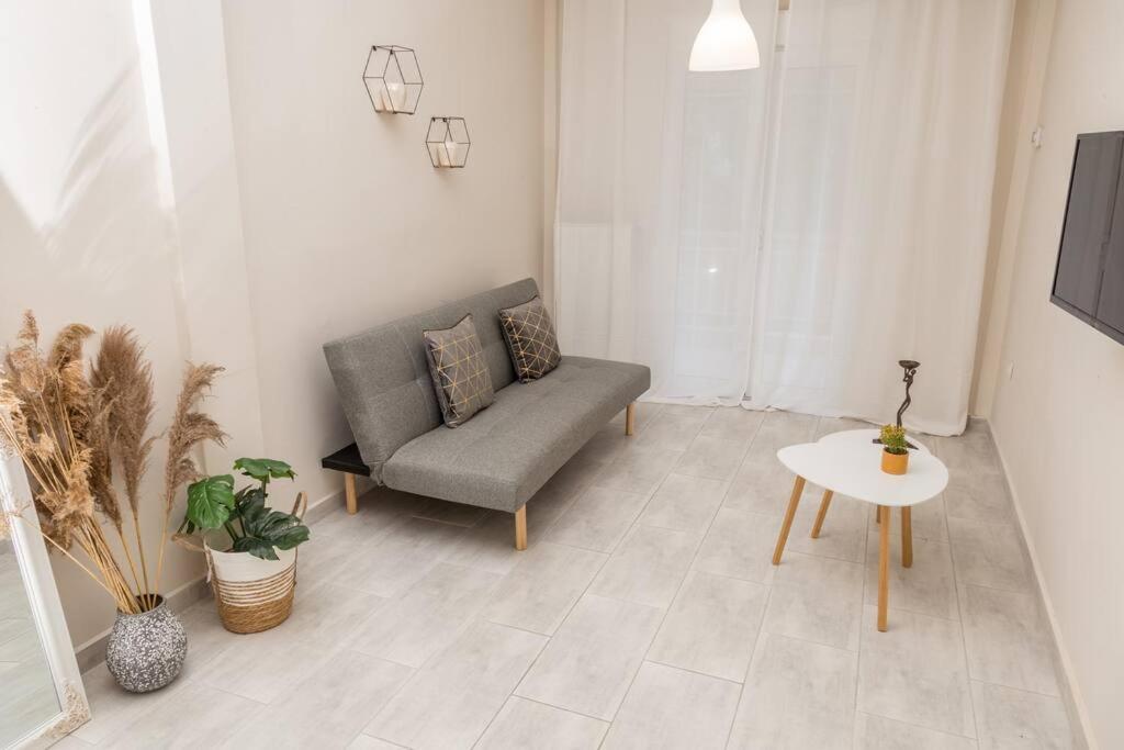ein Wohnzimmer mit einem Sofa und einem Tisch in der Unterkunft Simplicity Big Apartment in Thessaloniki