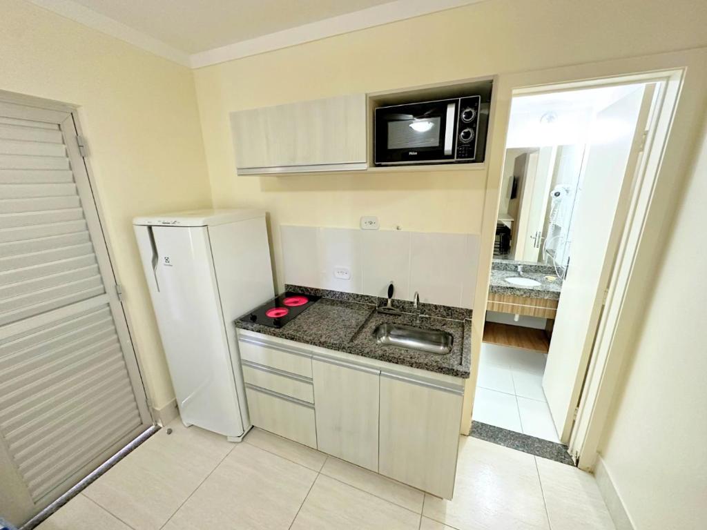 een kleine keuken met een wastafel en een koelkast bij Lacqua Diroma parque - CN J in Caldas Novas