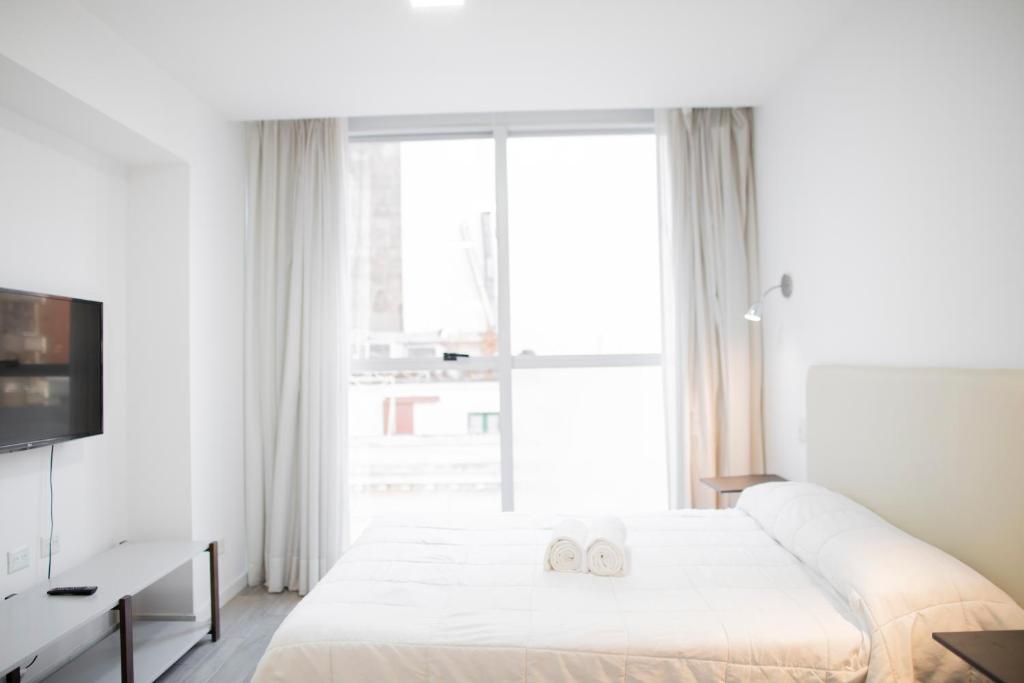 a bedroom with a large bed with two towels on it at WeSleep Paraguay Departamentos en Microcentro in Buenos Aires