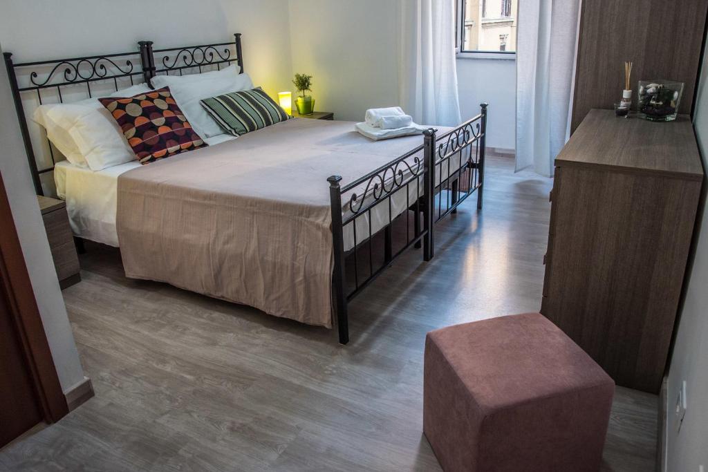 - une chambre avec un grand lit et du parquet dans l'établissement Grandis Rooms, à Rome