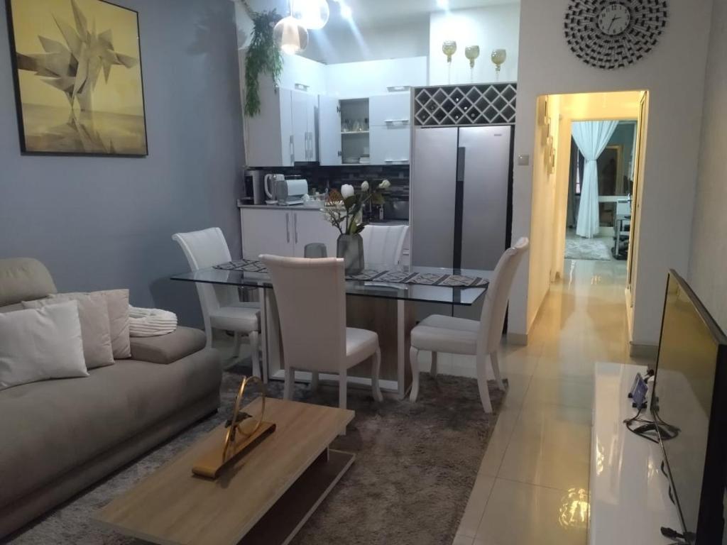 uma sala de estar e cozinha com uma mesa e um sofá em A vista perfeita em Luanda