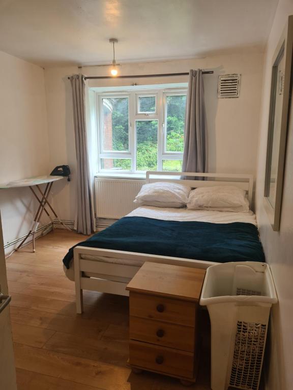 a bedroom with a bed with a window and a table at Vivian House in London