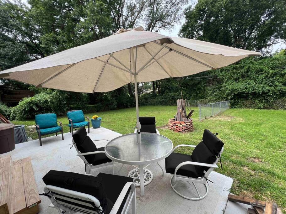 a patio with a table and chairs under an umbrella at Cozy two bedroom home near downtown Shawnee in Shawnee