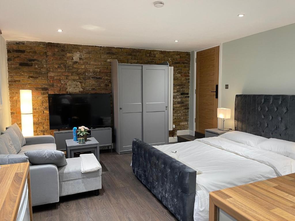 una camera con un grande letto e un soggiorno di Cosy Studio Flat with Balcony in Heart of London a Londra