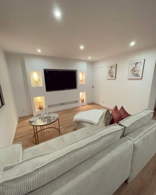un salon avec un canapé et une télévision à écran plat dans l'établissement T3 Haut standing, à Saint-Raphaël