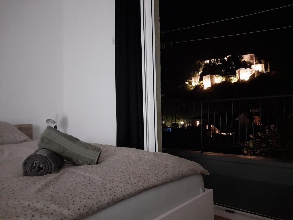 uma cama com uma almofada e uma janela à noite em Apartman Benat em Stolac