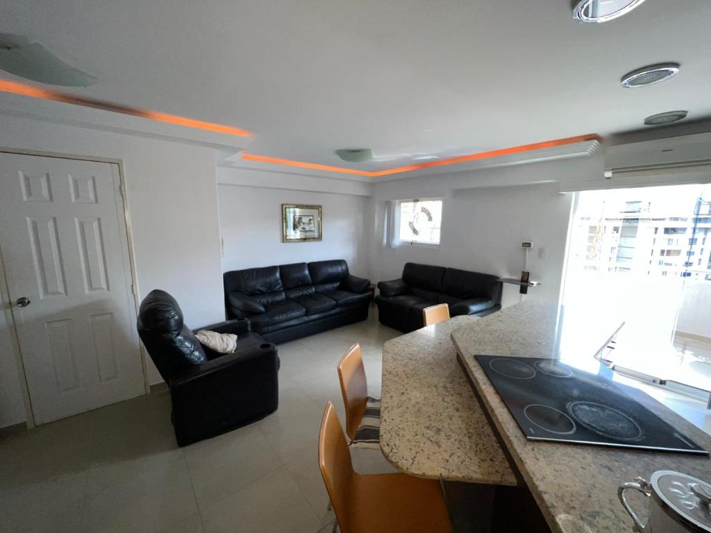 a living room with a black couch and a table at Cómodo apartamento entero in Caracas