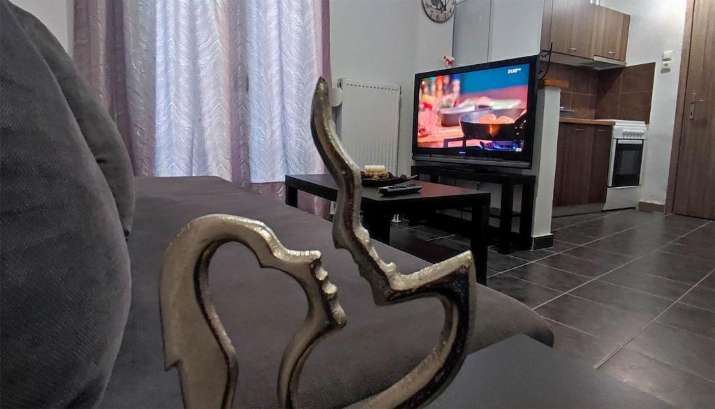 einen Stuhl vor einem Wohnzimmer mit einem TV in der Unterkunft Dreams 1 in Kardítsa