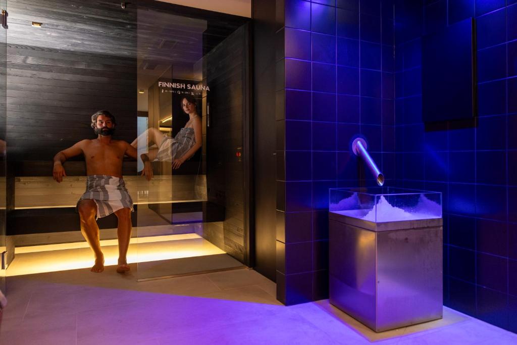 een man in een badkamer met een spiegel bij Wellness Smart Suites in Bolzano