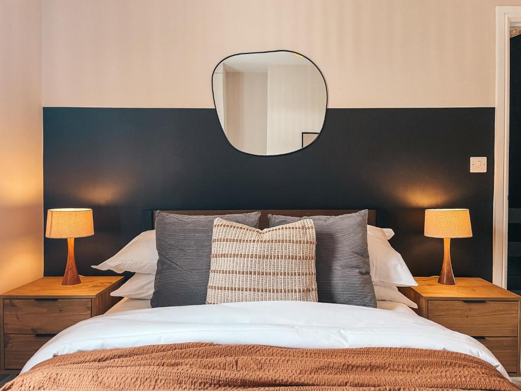a bedroom with a large bed with a mirror on the wall at Rosslyn House by Solace Stays in Newport