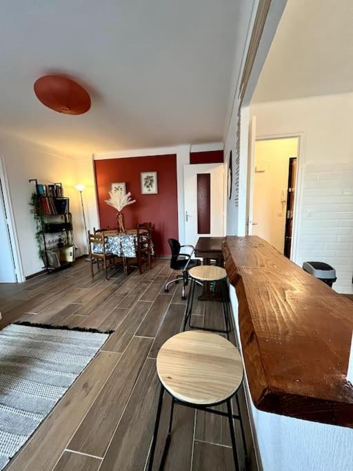 un salon avec une table et des chaises en bois dans l'établissement Agréable T2 cosy - centre-ville, à Perpignan