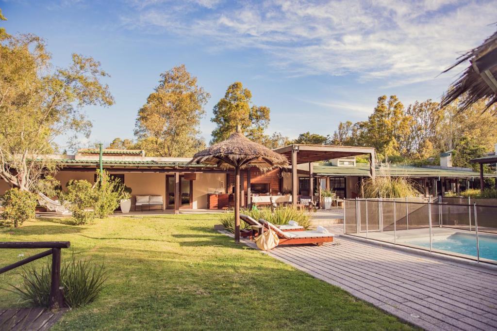 a house with a garden and a swimming pool at Casa Shanti - La Barra in Punta del Este