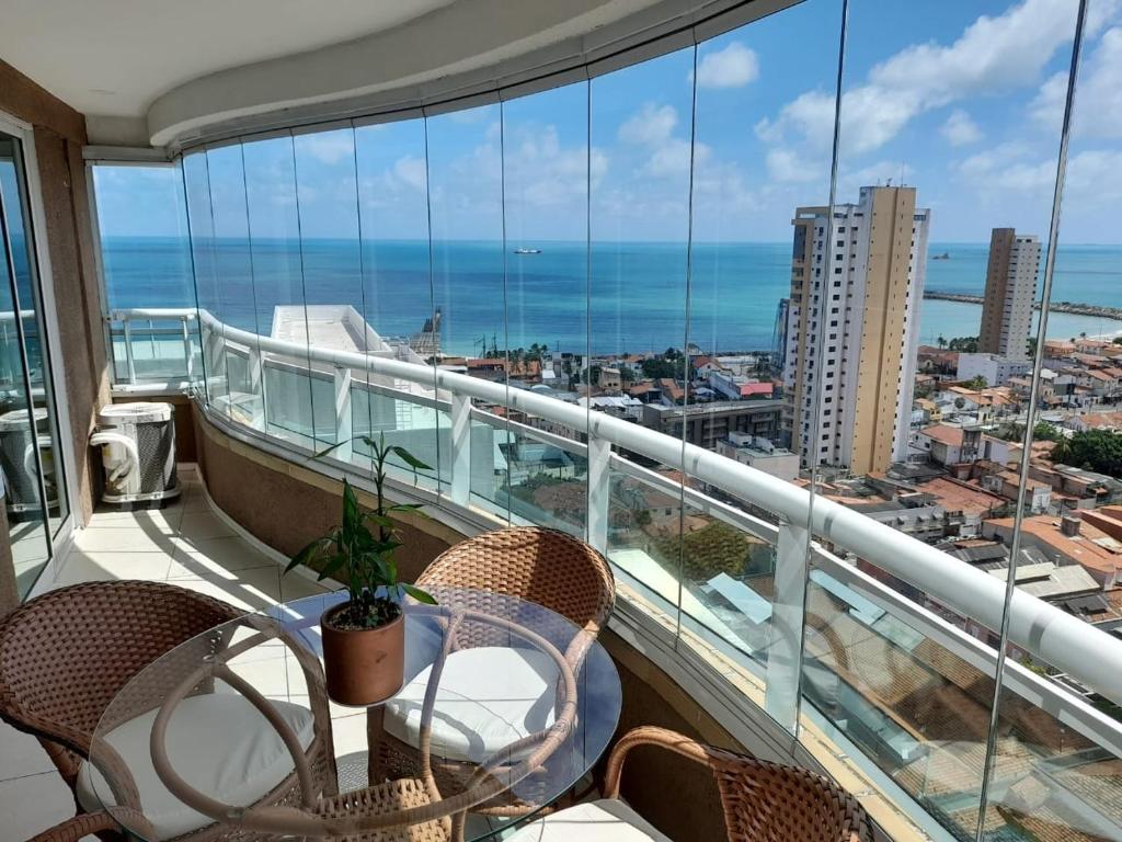 a balcony with a table and chairs and a view of the ocean at Studio Iracema 2001 in Fortaleza
