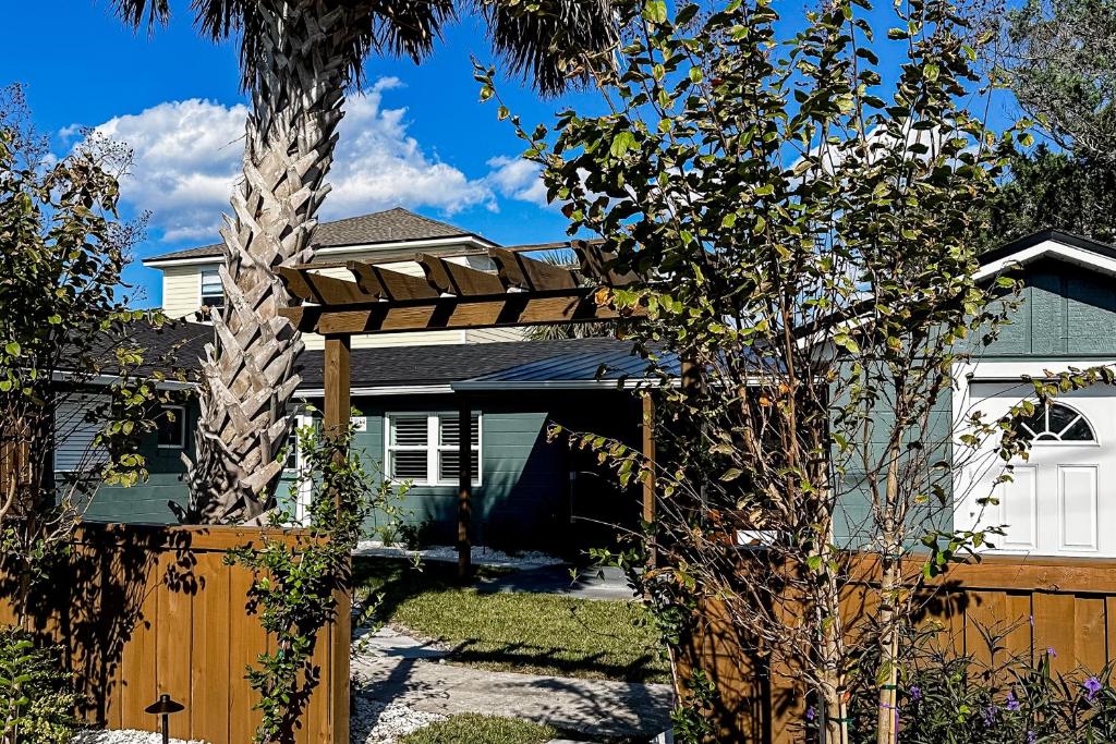 a wooden pergola in front of a house at Palmetto Paradise - B in St. Augustine