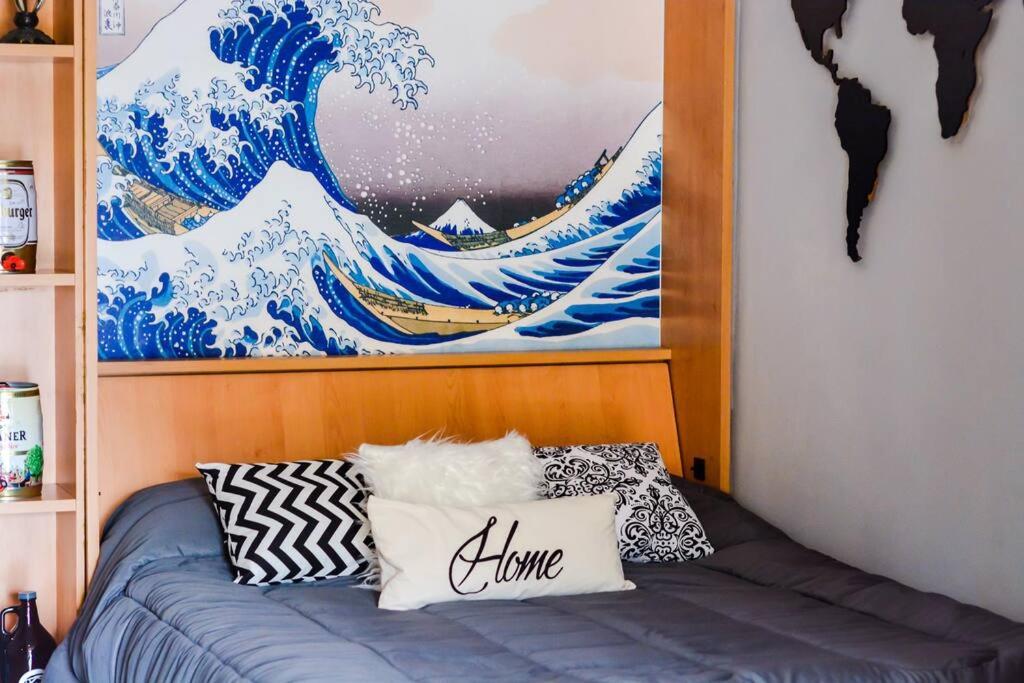 a bedroom with a large painting of the great wave at Luminoso con Cochera, Balcón, Hamaca y Parilla in Paraná