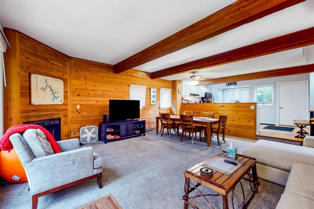 Una sala de estar con un sofá, un televisor y una mesa. en Hibernation Hideaway, en McHenry
