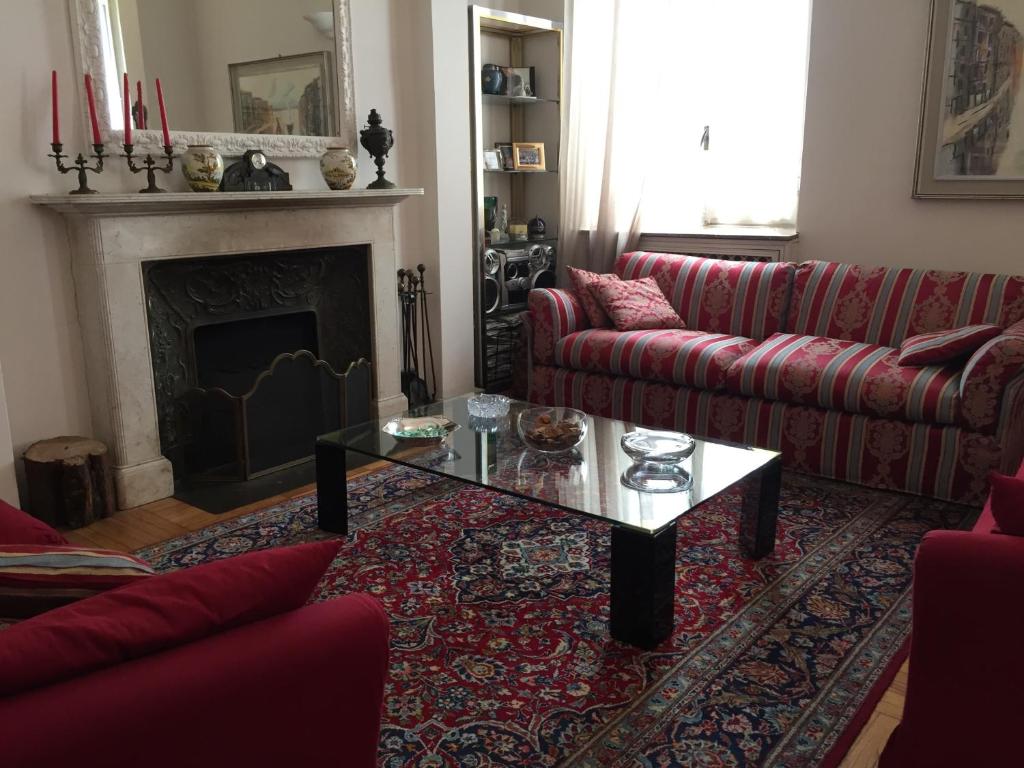 un soggiorno con divano rosso e tavolino da caffè di Il Giardino Nascosto a Busto Arsizio