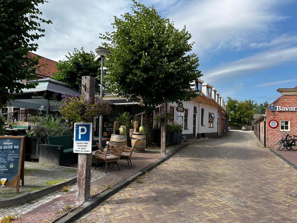 una calle con una señal de estacionamiento frente a un edificio en Hotel Onder De Linden, en Roden