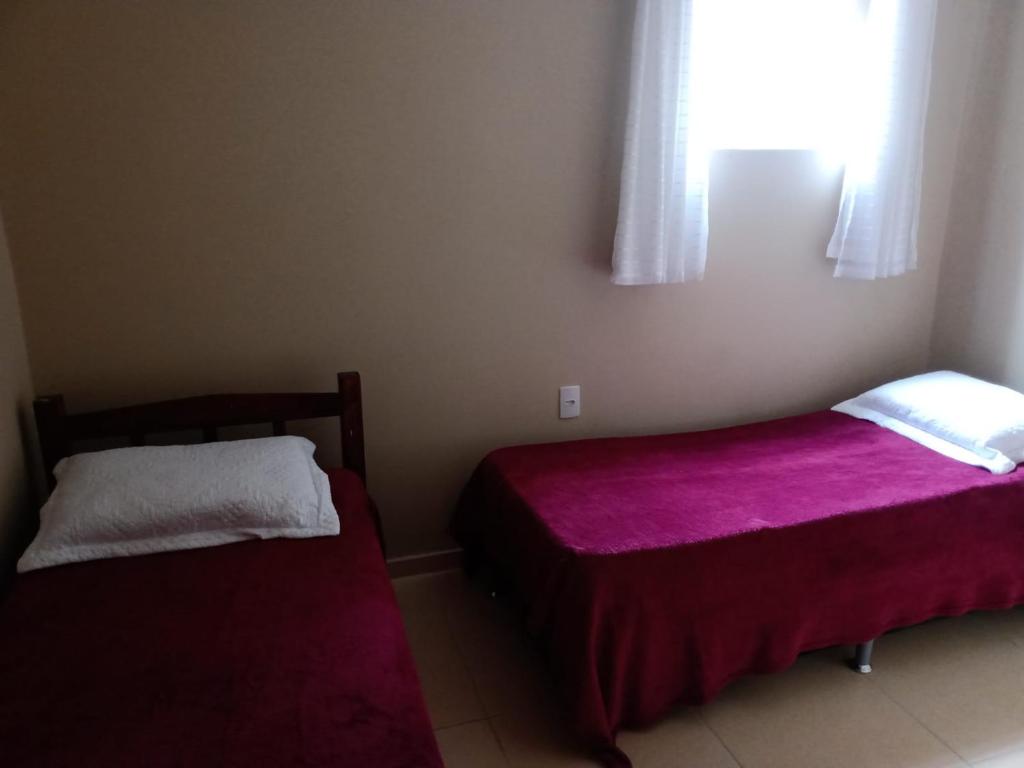 a bedroom with two beds and a window at Apê perto do Parque Euclides Dourado in Garanhuns