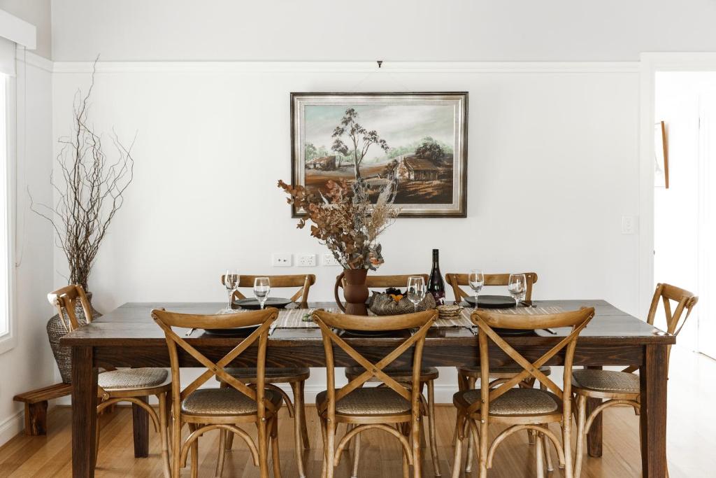 a dining room with a wooden table and chairs at Hey Little Joe - Cosy Retreat with Mountain Views in Warburton