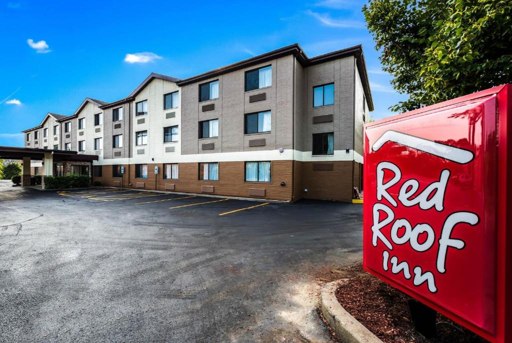 a building with a red root sign in a parking lot at Red Roof Inn Palatine in Palatine