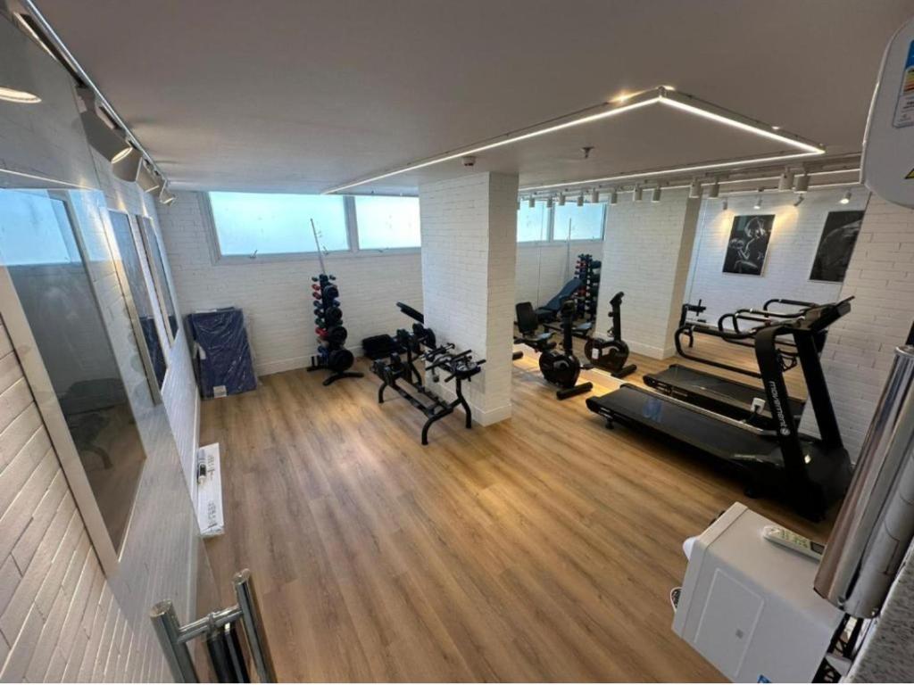 a gym with treadmills and exercise bikes in a room at Quarto com acabamento superior no Design Hotel Linhares in Linhares